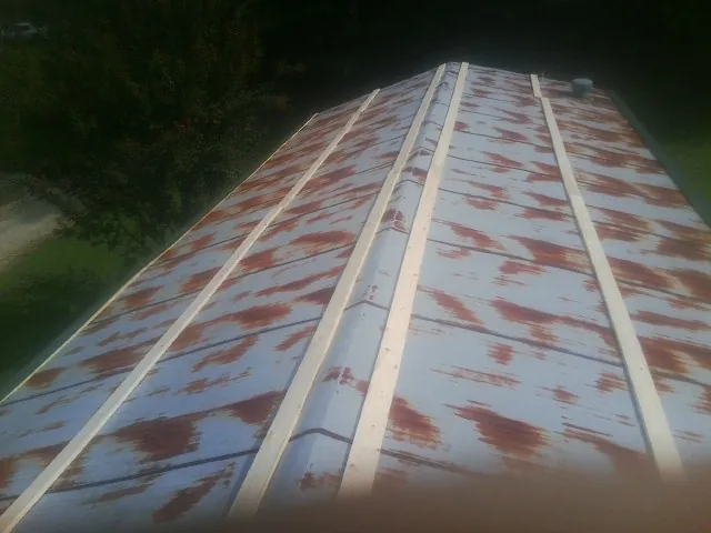 Rusted metal roof panels with new wood purlins before replacement — Storm Damage Roof Repair in Odell by Roofing Brothers