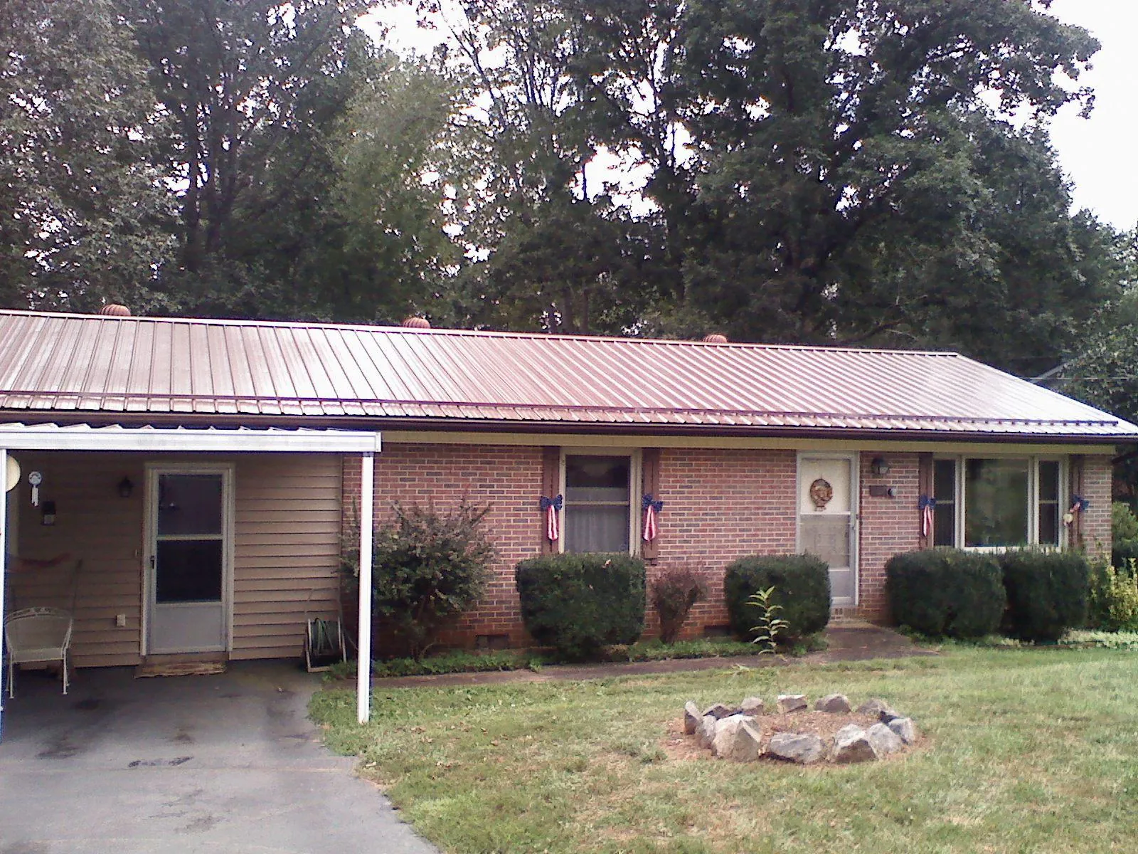 Bronze metal roof and carport on a brick ranch home — Roof Repair work by our crew in Odell
